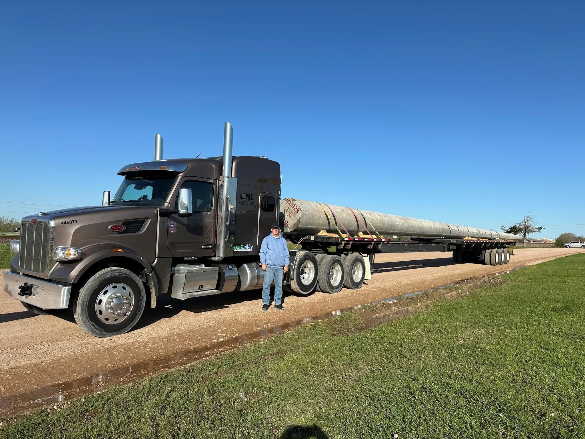 Highway Haulers team member posed in front of a gray truck cab.